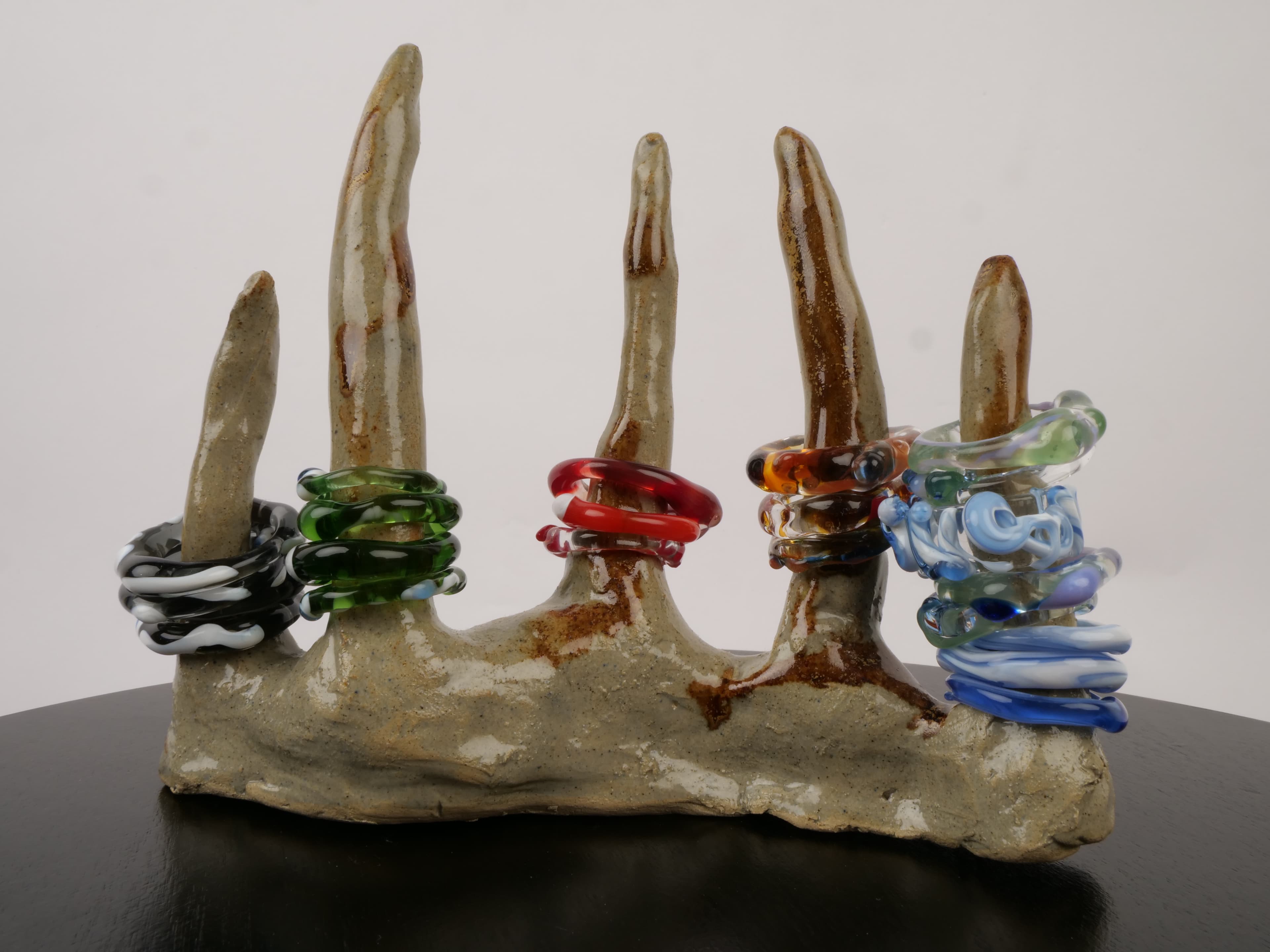 Coloured glass rings on ceramic hand